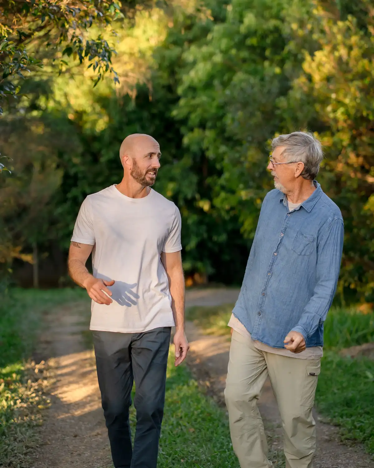 Two older adults together outdoors in warm afternoon light
