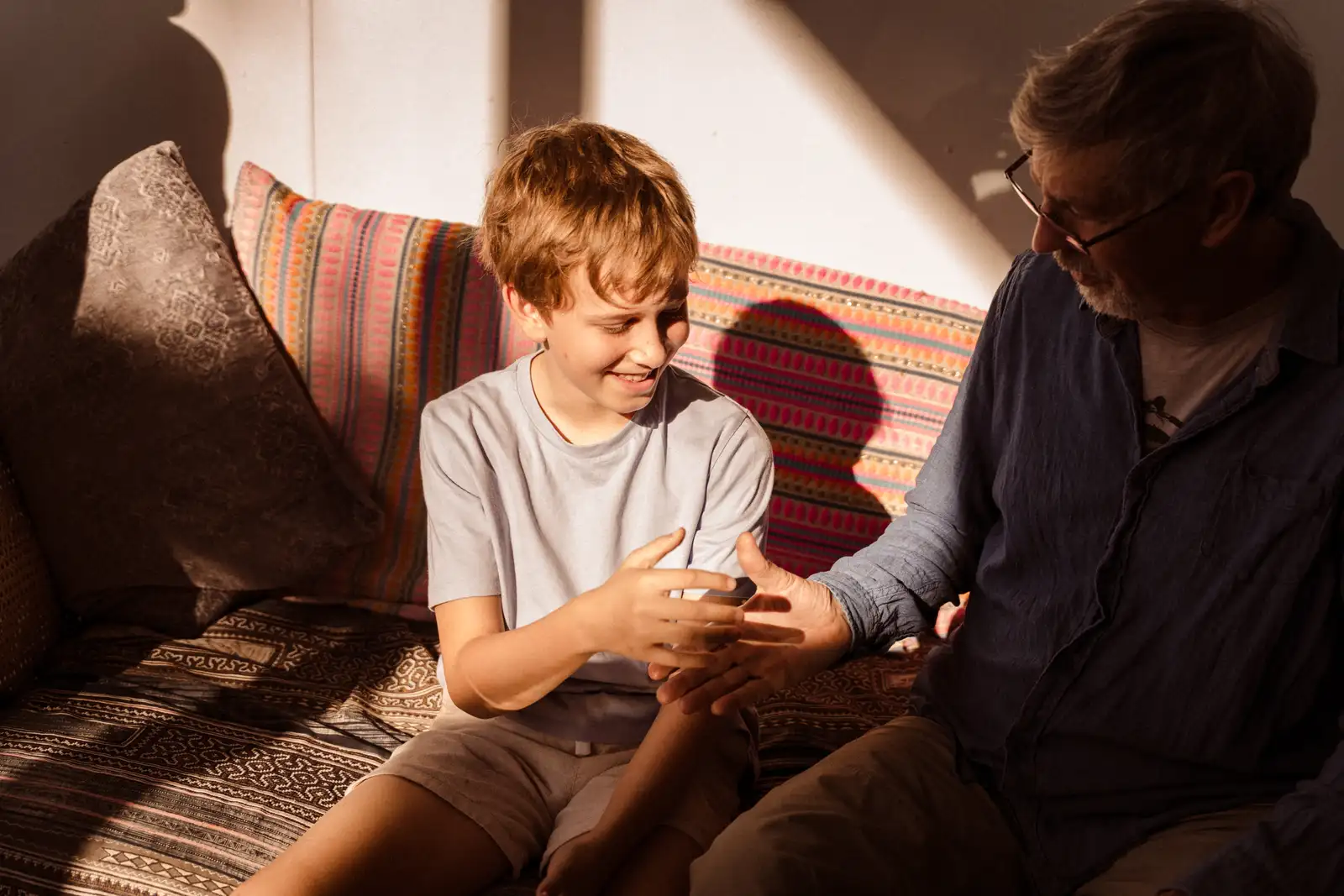 A child and an adult sharing a hands-on activity on a sofa