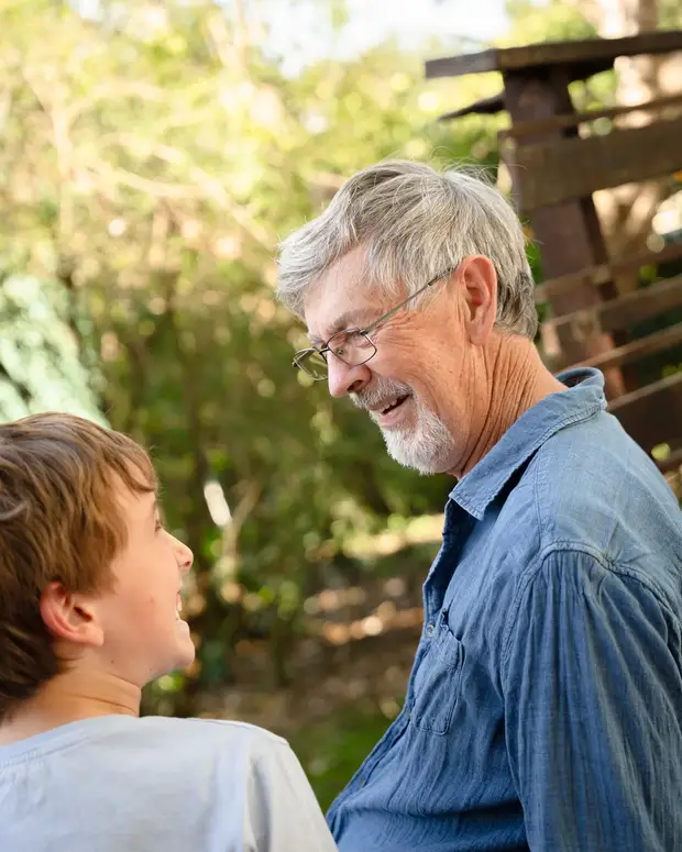 An adult and a young person sitting together outdoors